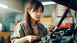 © Ketanoff - Asian woman repairing a car at a service station. Generated with AI