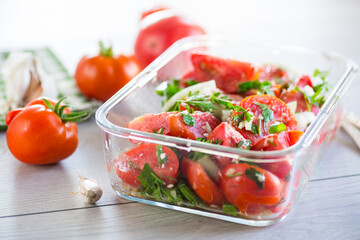 Sticker - Spicy snack tomatoes with garlic, herbs, seasonings and onions in a glass bowl .