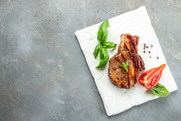 Wall Mural - Roasted pork steak, cutlets with bone on a light background. Restaurant menu, dieting, cookbook recipe top view