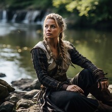 A Woman Viking Resting Near A Lake After Fighting.