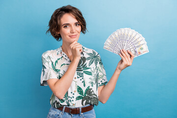 Sticker - Photo of funky thoughtful woman dressed print shirt rising cash fan arm chin isolated blue color background