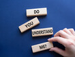 © Natallia - Do you understand me symbol. Concept words Do you understand me on wooden blocks. Beautiful deep blue background. Businessman hand. Business and Do you understand me concept. Copy space.