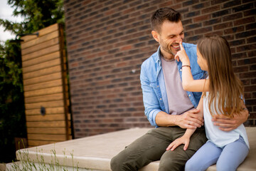 Wall Mural - Father and his daughter have a good time in front of house door