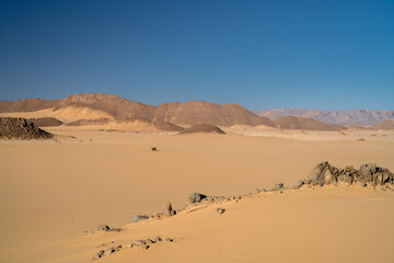 Poster - view in the Sahara desert of Tadrart rouge tassili najer in Djanet City  ,Algeria.colorful orange sand, rocky mountains