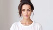 © Ameer - Portrait of beautiful serious brunette woman focused at camera has dark hair combed in bun dressed in casual t shirt isolated over white background. Confident Indian female model with calm expression