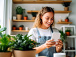 © YuliiaMazurkevych - Young latin shopkeeper girl smiling happy using smartphone at florist.
