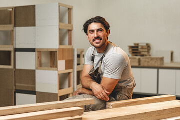 Wall Mural - Portrait of young male carpenter standing in the wood workshop