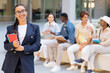 © Prostock-studio - Cheerful young woman posing over multicultural group of students