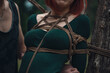 breast of beautiful redhead woman in green body tied with shibari rope Kinbaku japanese bandage
