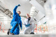 © Connect Images - Kneeling men using torch underneath airplane