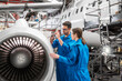 © Connect Images - Man and woman working on airplane engine