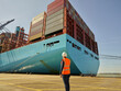 © Connect Images - Dock looking up towards blue cargo ship with containers, Felixstowe, England.