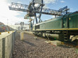 © Connect Images - Train on tracks with cargo cranes in docks, Felixstowe, England.
