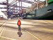 © Connect Images - Female dock worker in protective workwear standing by cargo ship, Felixstowe, England.