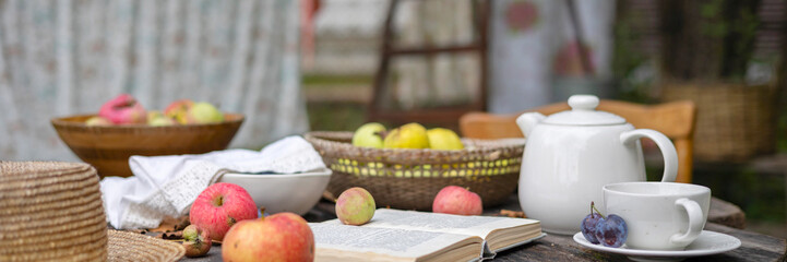 wooden table set for tea in the garden under an apple tree next to the ropes where the laundry is dried, cozy and comfortable autumn still life