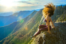 Young Woman Tossing Her Hair On A Mountain Rock