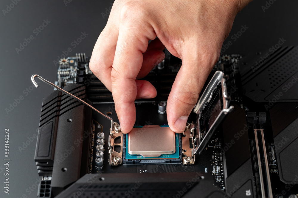 Computer CPU installation. Hand of master installs processor chip on ...