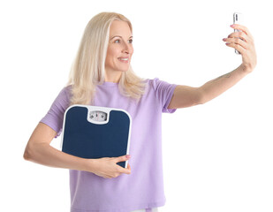 Poster - Mature woman with scales and mobile phone taking selfie on white background