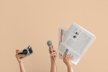 Poster - Female hands with photo camera, microphone and newspapers on color background