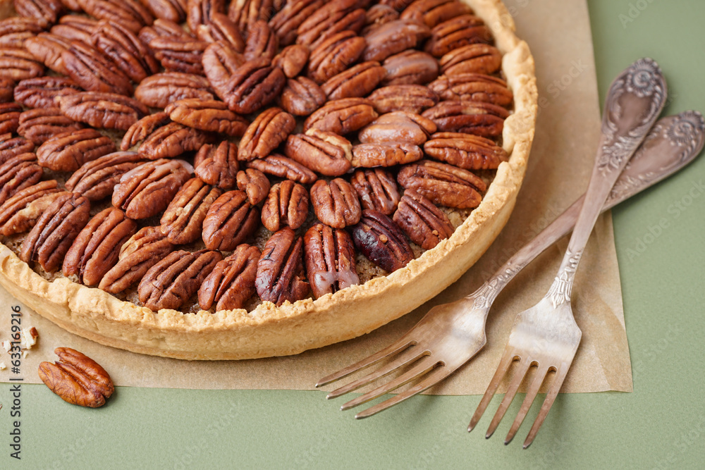 Tasty pecan pie on green background