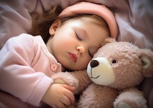 Little Girl Sleeping In Bed Hugging A Teddy Bear