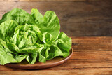Fototapeta Kuchnia - Fresh green butter lettuce on wooden table, space for text