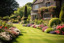 The Picturesque Sight Of A Stunning English Style Garden, Showcasing A Lush, Neatly Trimmed Lawn And A Vibrant Flower Bed.