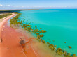 Red sandy coastline along turquoise water at Red Sand Beach, Roebuck Bay, Broome, Western Australia
