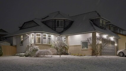 Wall Mural - Establishing shot of luxury house with nice landscape at winter snowfall at night in Vancouver, Canada, North America. Night time on December 2022. ProRes 422 HQ.