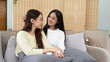 © itchaznong - Loving LGBTQIA lesbian gay couple laughing together in Livingroom. Asian LGBTQIA lesbian gay couple laughed happy together while sitting on the sofa. Homosexual-LGBTQ concept.