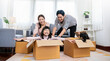 © paulaphoto - Asian family father mother daughter girl packing cardboard box relocation moving to new house, online marketing e-commerce unpacking stuff belongings home delivery. Lifestyle asian family together