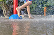 © Naige - On a hot summer day, children are running around in the city's water splash pad playground.