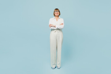 Wall Mural - Full body employee business woman 50s wear white classic suit glasses formal clothes hold hands crossed folded look camera isolated on plain pastel light blue background. Achievement career concept.