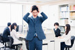 © maroke - オフィスで頭を抱える若いビジネスマン