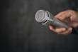 Silver microphone hold in hand. Microphone can amplify the sound lounder for the singer, orator, politician, complainant, teacher, MC and announcer or call for peace.