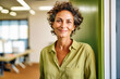 Smiling senior business woman in green attire, female teacher in classroom