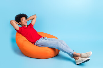 Canvas Print - Full length body photo of satisfied chill millennial man student after lectures lying bean bag dormitory isolated on blue color background