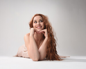 Sticker - Full length portrait of beautiful brunette model  wearing a  pink dress. graceful sitting  pose, kneeling on floor gestural hands. shot from low angle perspective,  isolated on white studio background