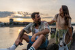 © Srdjan - Smiling hipster people spending time together outdoors. Young millennial couple in love enjoying sunny evening happiness and lifestyle concept.