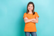 © deagreez - Portrait of good mood nice schoolgirl dressed orange t-shirt arms crossed look empty space promo isolated on turquoise color background