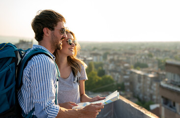 Wall Mural - happy tourists couple, friends sightseeing city with map together. travel people concept.