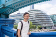 LONDON, UK, 21 june 2023: City Hall and Tower Bridge  riverside tourist attraction River Thames Norman Foster business people  rushing to their work, man white t-short portrait backpack tourist .
