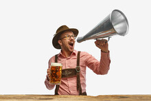 Portrait Of Man Wearing Traditional Bavarian Or German Oyfit Shouting In Vintage Megaphone And Inviting To Beer Party. Oktoberfest Concept