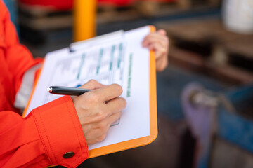 Wall Mural - action of a supervisor is using a pen to writing on chemical hazardous material paper form to rating