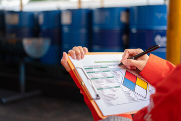 a safety officer is checking on the hazardous material checklist form with chemical storage area at 