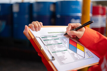 Wall Mural - a safety officer is checking on the hazardous material checklist form with chemical storage area at 