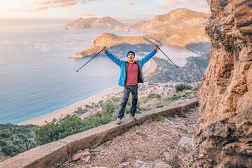Wall Mural - Happy man admiring view of a scenic sunrise over Oludeniz town in Turkey. Lycian Way travel sights and adventures