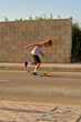 © ADDICTIVE STOCK CORE - Active boy riding skateboard along roadway