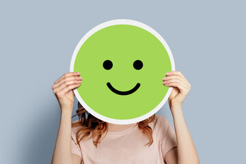 Girl holding a paper poster with a happy cheerful smiley