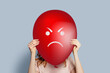 girl holding balloon with angry face